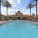 a swimming pool with palm trees and a building in the background