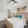 a bedroom with a bed and lamps with ceiling fan and connected closet and bathroom