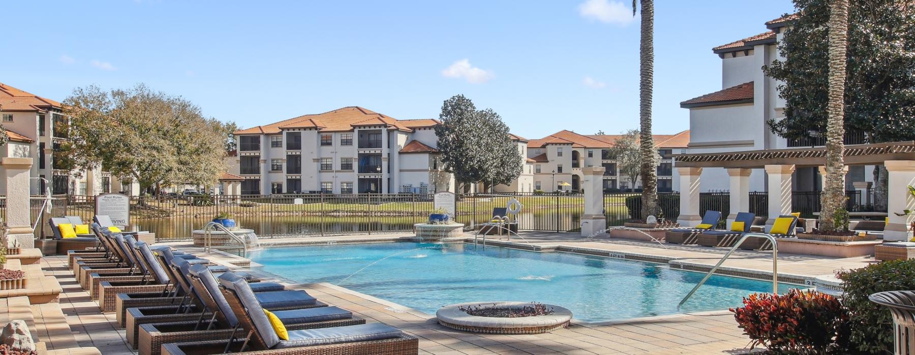 a swimming pool with lounge chairs around it